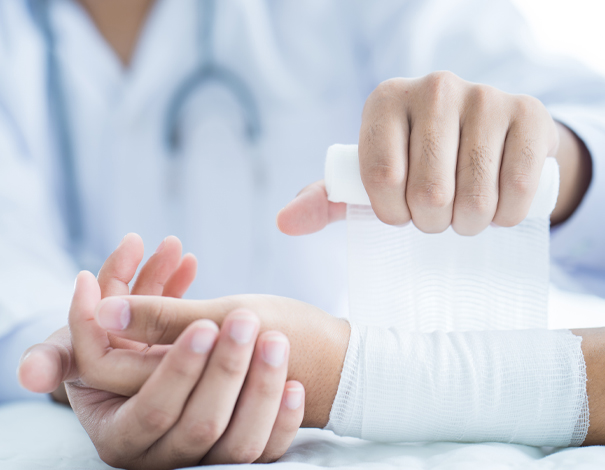 doctor wrapping person's hand in gauze
