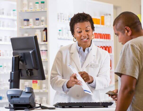 Female pharmacist giving advices on how to take medication to a patient