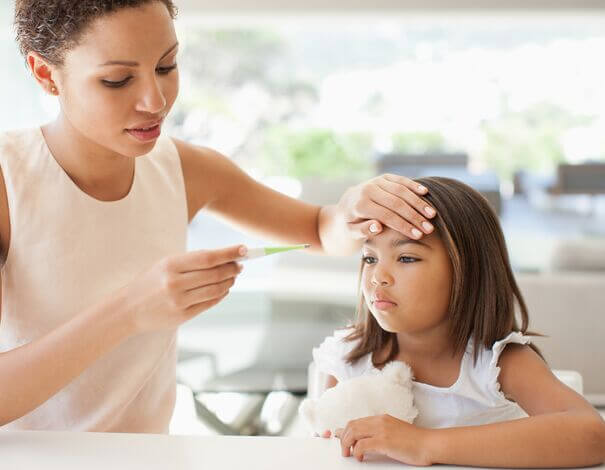 mother taking daugther temperature