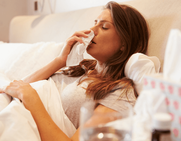 woman in bed with flu, cold and covid-19 symptoms