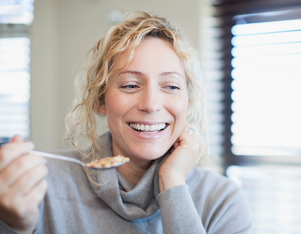 woman smiling and eating cereal