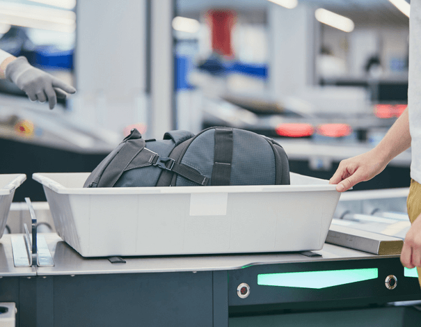 Bin with travel bag passing security check at airport Bin with travel bag passing security check at airport