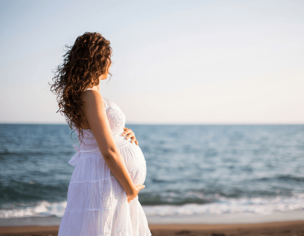 Backview of a pregnant woman on the beach Backview of a pregnant woman on the beach