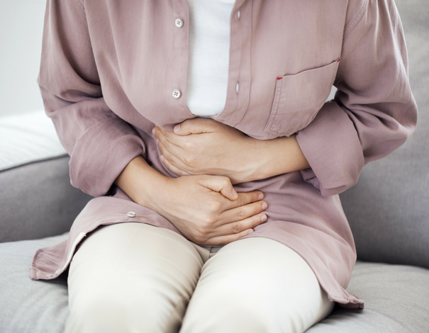 Woman holding her belly has her gut hurts with traveller's diarrhea