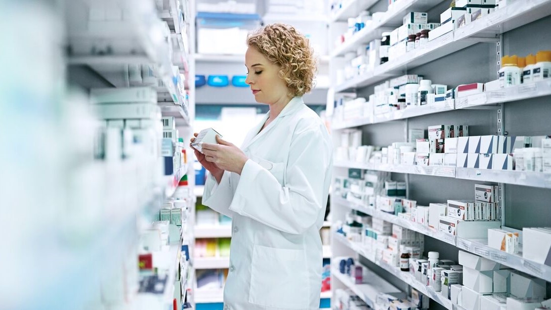 Pharmacist looking through pharmacy shelves